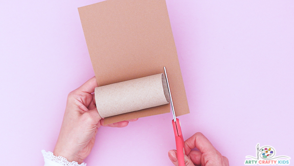 Image showing a hand aligning a paper roll along a strip of brown paper.