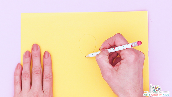 Image showing a hand drawing a tear drop showing onto some yellow paper.