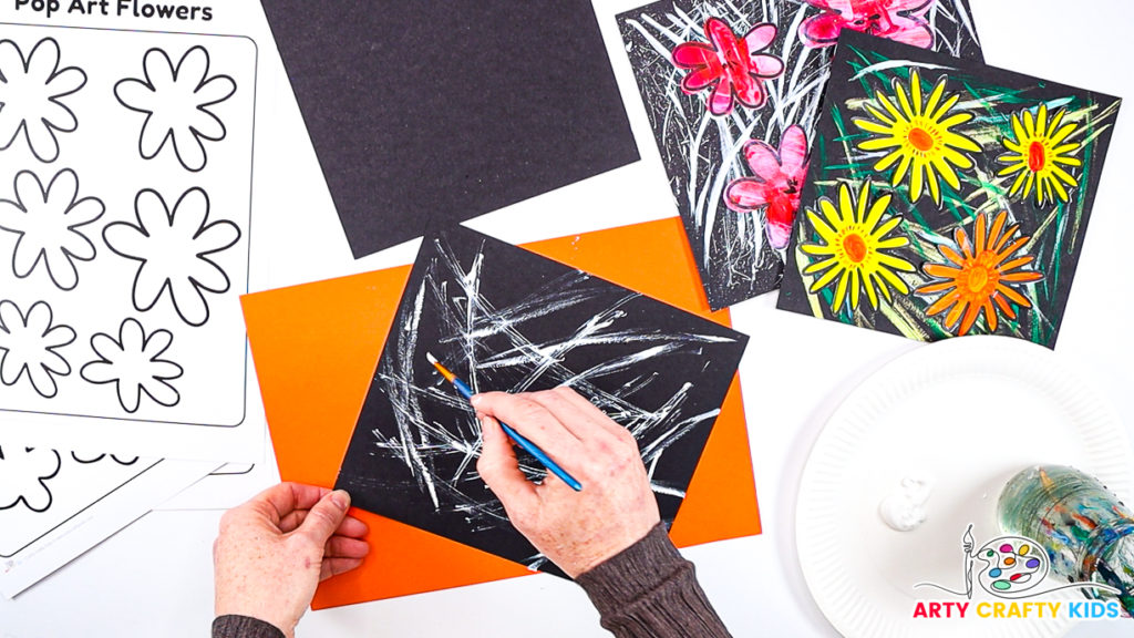 Image of a hand continuing to paint random lines across the black piece of cardstock.