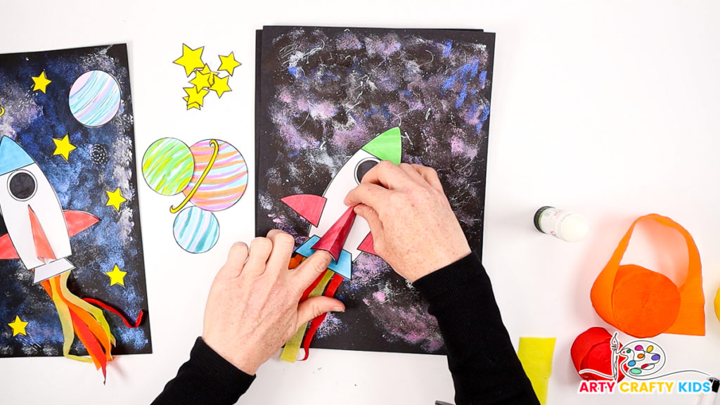 Image of a hand gluing 3D element onto the spaceship.