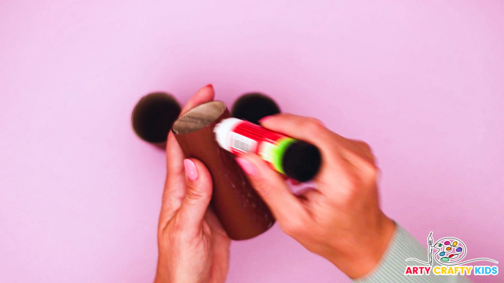 Image of a hand applying glue to the a paper roll.