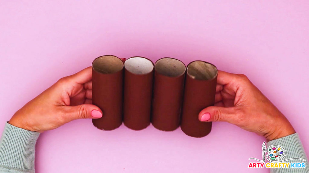 Image of hands securing the four paper rolls into a line.