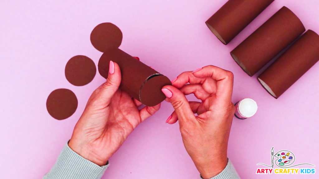 Image of a hand affixing the bases onto the paper rolls.