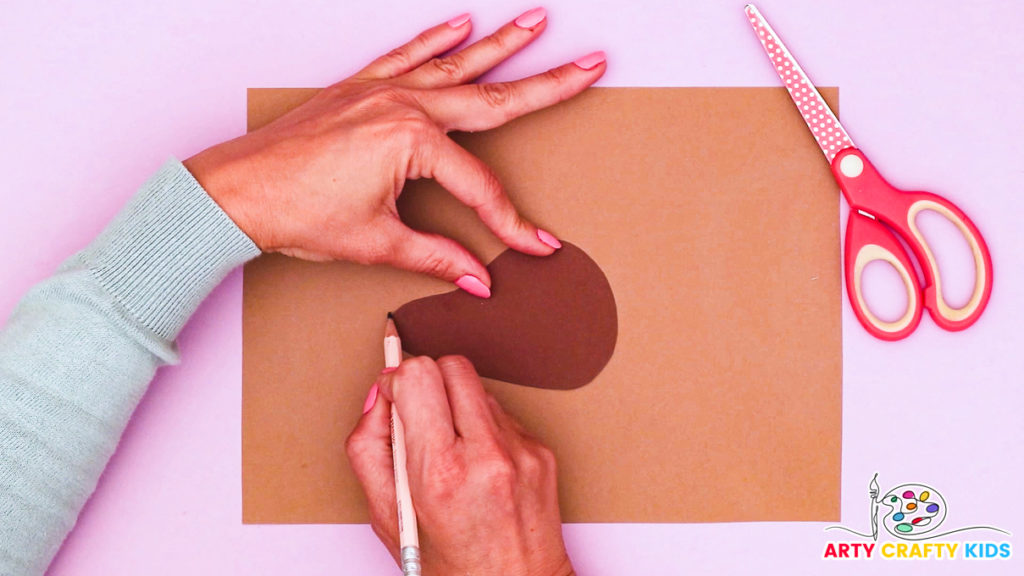 Image of a hand tracing the brown head of the dog onto a lighter shade of brown to create a two-toned effect on the face.