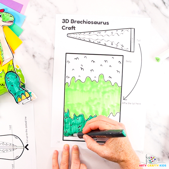 Image of a hand coloring the 3D brachiosaurus dinosaur craft template.