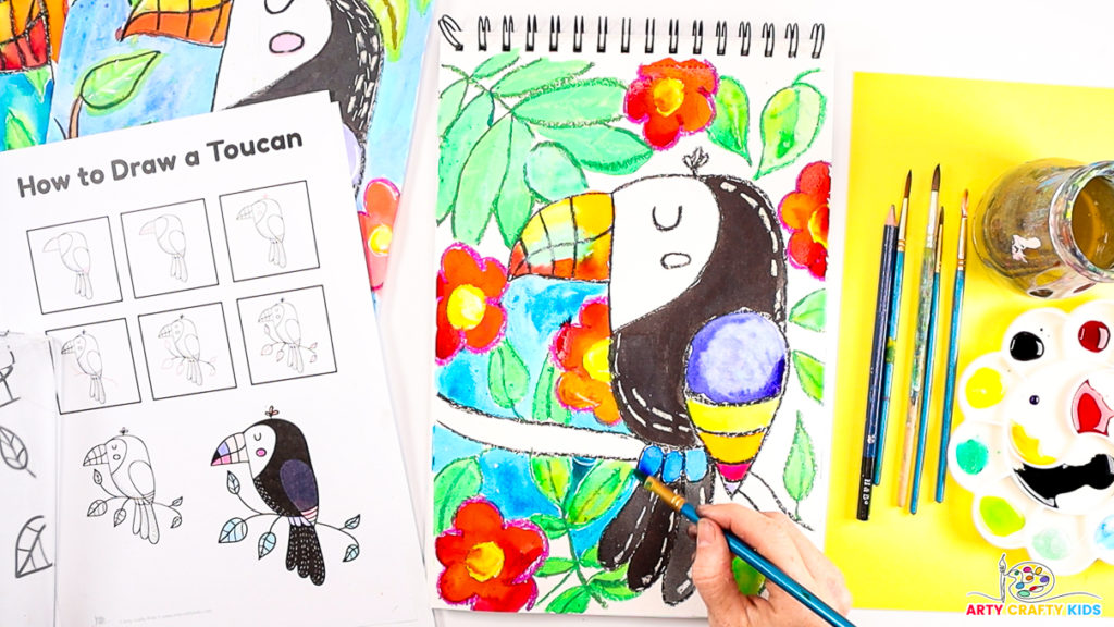 Image features a hand painting the toucan and background in colorful shades.