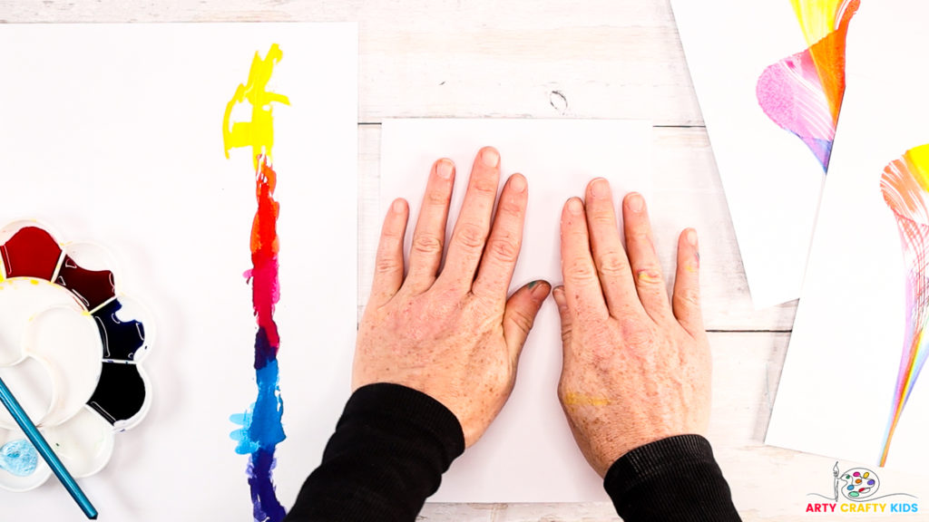 Step 4: Image of a hand folding a piece of paper over and pressing down onto the string.