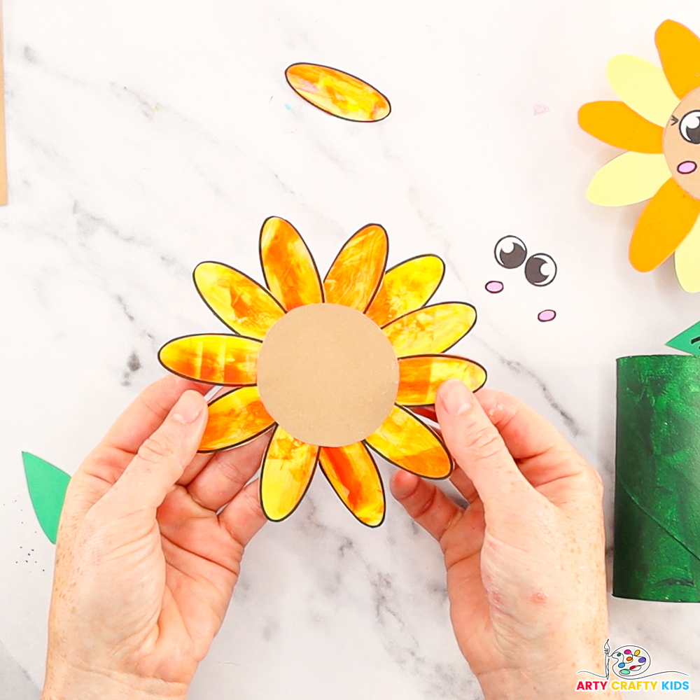 Image features a hand holding up the completed sunflower head.