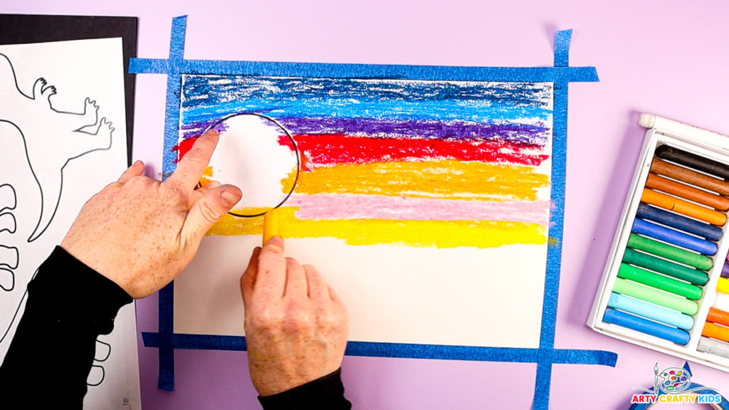 Image of a hand creating the sky, adding pink, orange and yellow pastel colors spread horizontally across the page.