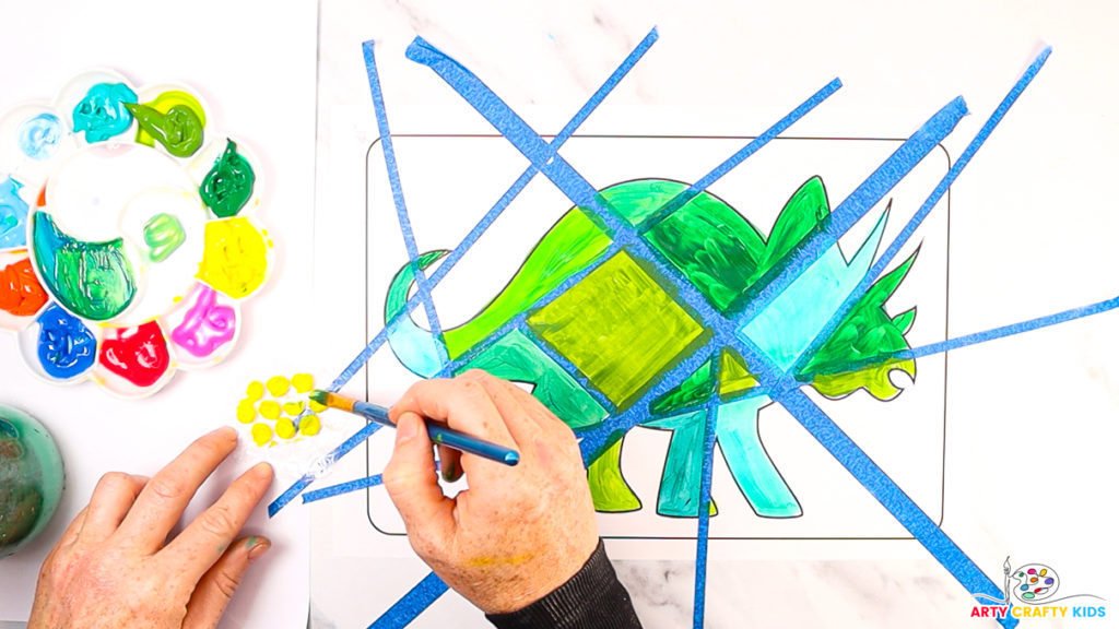 Image of a hand painting the bubbles on bubble wrap yellow.