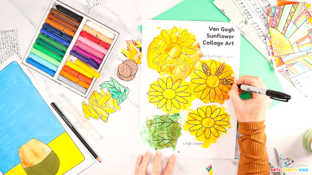 Image of a hand using a black marker pen to doodle within the petals of one of the base sunflowers.