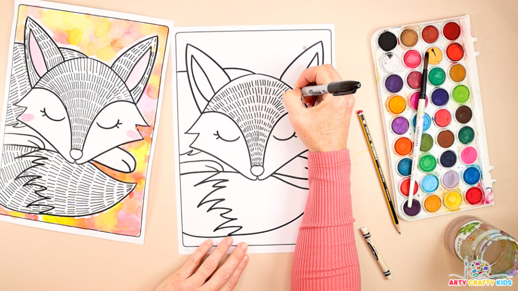 Image of a hand drawing a series of lines with the head area of the fox.