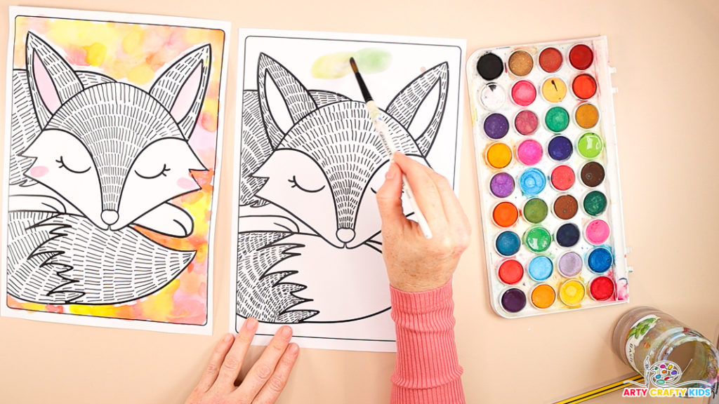 An image shows a hand painting watercolor circles around the fox's head in green.