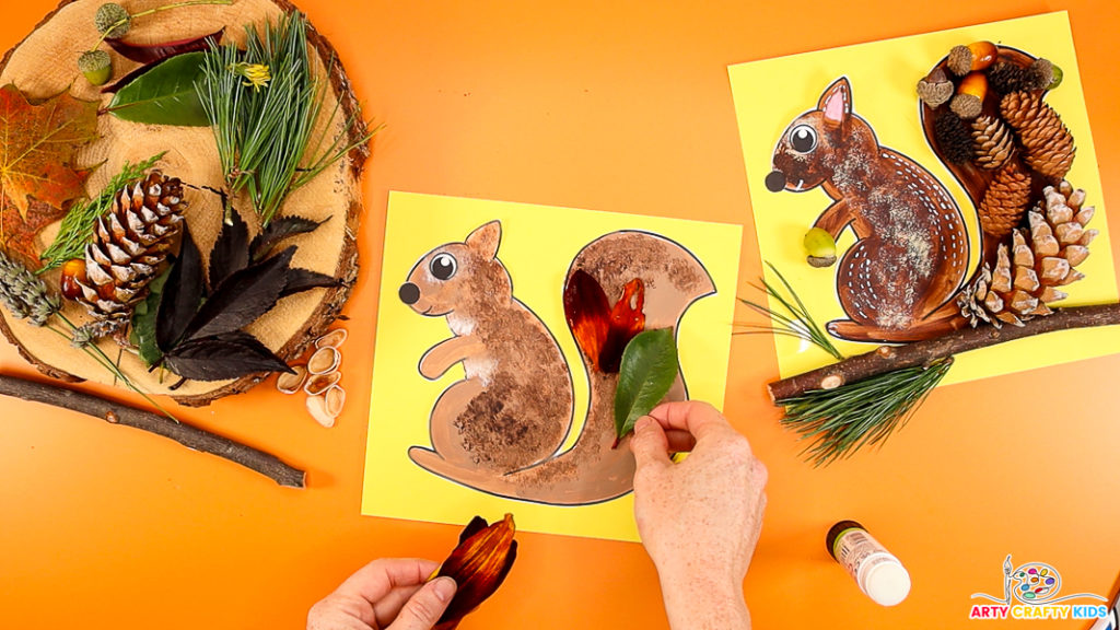 Image of a hand layering petals and leaves within the squirrel's tail.