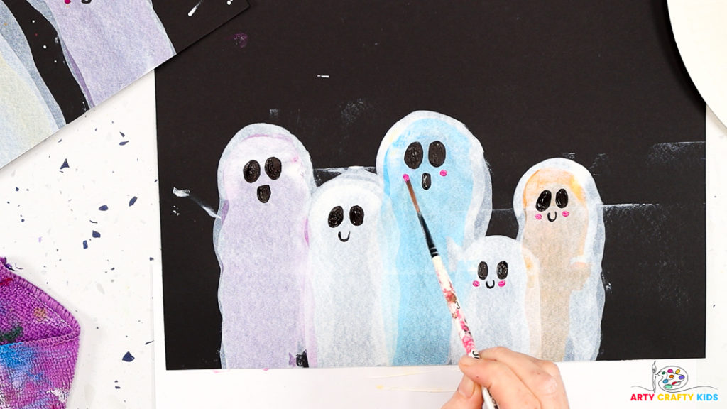 Image of a hand painting cute pink cheeks to complete the ghostly facial expressions.