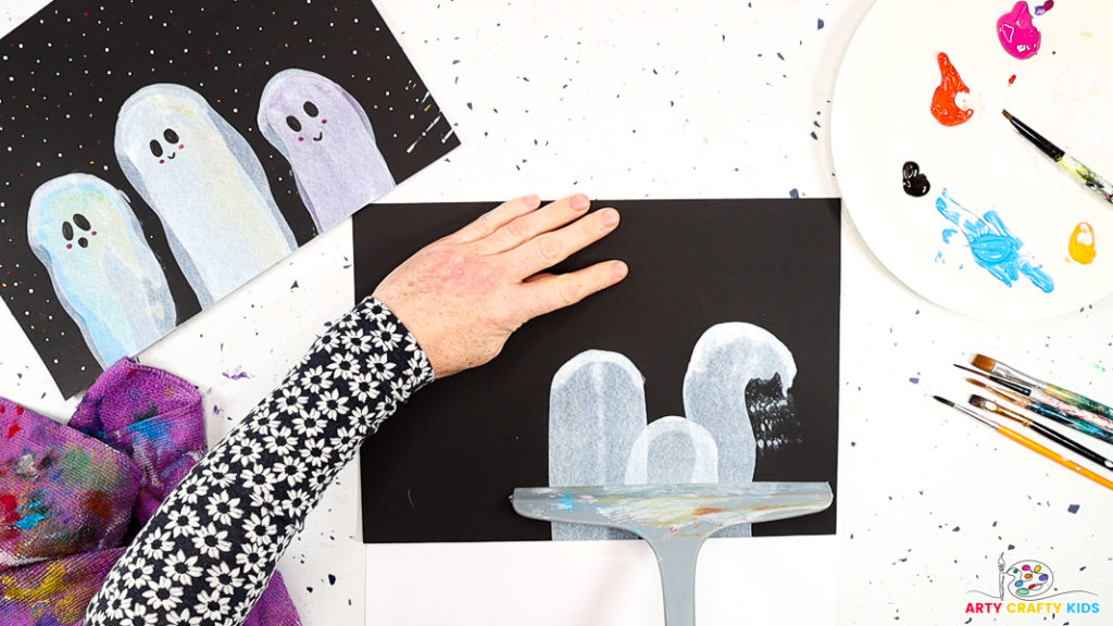 Image of a hand creating a small squeegee ghost that's layered above two other ghosts.