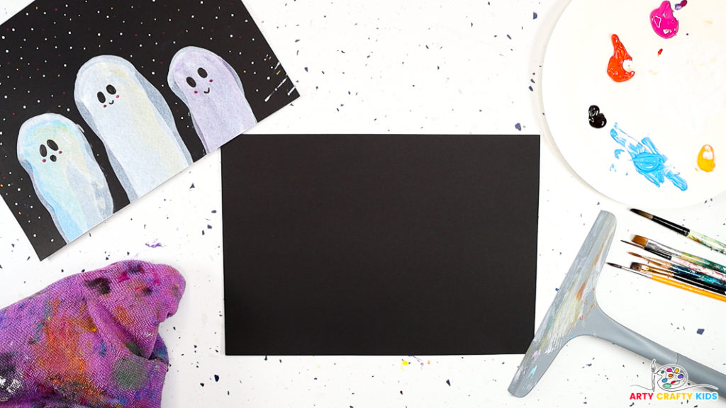 Image of the materials used for Easy Squeegee Ghost Art for Halloween, featuring black card stock, a cloth, squeegee, paintbrushes and paint.