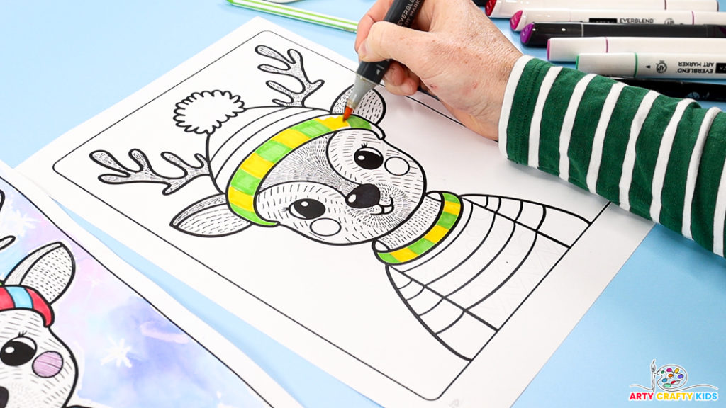 Image of a hand coloring the hat and sweater with striped yellow and green blocks.