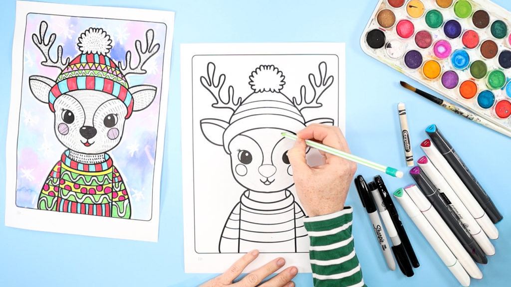 Image featuring a hand using a pencil to draw arches within the reindeer line art template.