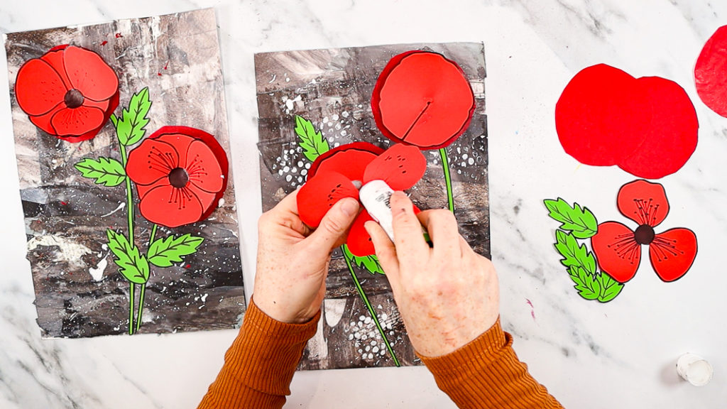 Image features a hand applying glue to the back of the top poppy layer.