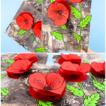 3D Remembrance Day poppy craft with red tissue paper poppies on a layered monochrome background.