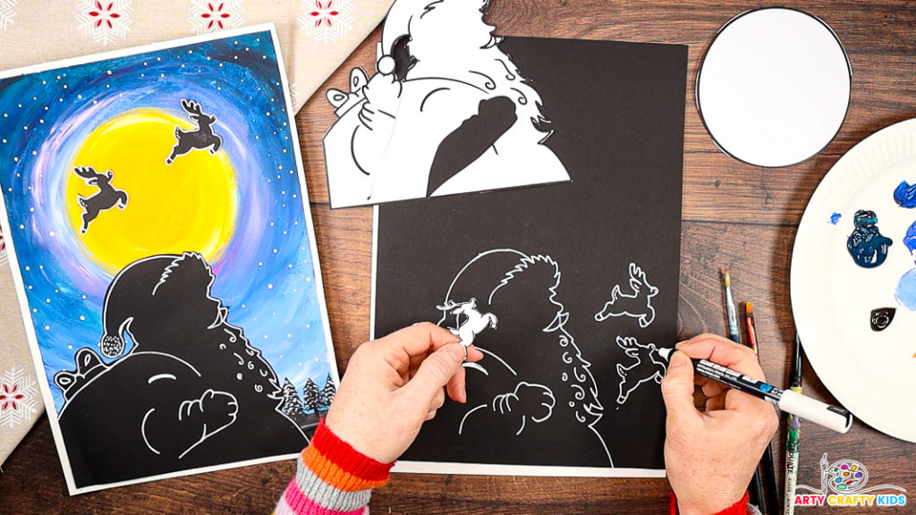 The image features a hand drawing around the reindeer templates with a white pen and adding simple detailing.