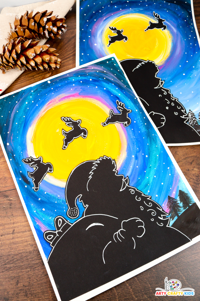 A festive Santa silhouette art project featuring a glowing yellow moon, a vibrant blue and purple night sky, and reindeer silhouettes flying across the moon. The artwork includes fine details and is surrounded by rustic pinecones for a cozy holiday feel. Perfect for Christmas crafts with kids.