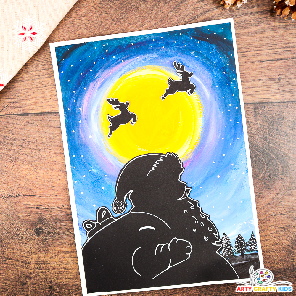 A festive Santa silhouette art project featuring a glowing yellow moon, a vibrant blue and purple night sky, and reindeer silhouettes flying across the moon. The artwork includes fine details and is surrounded by rustic pinecones for a cozy holiday feel. Perfect for Christmas crafts with kids.