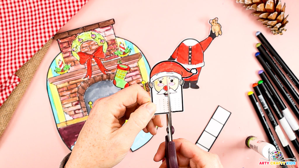 Image features a hand cutting along the dotted lines within Santa's beard.