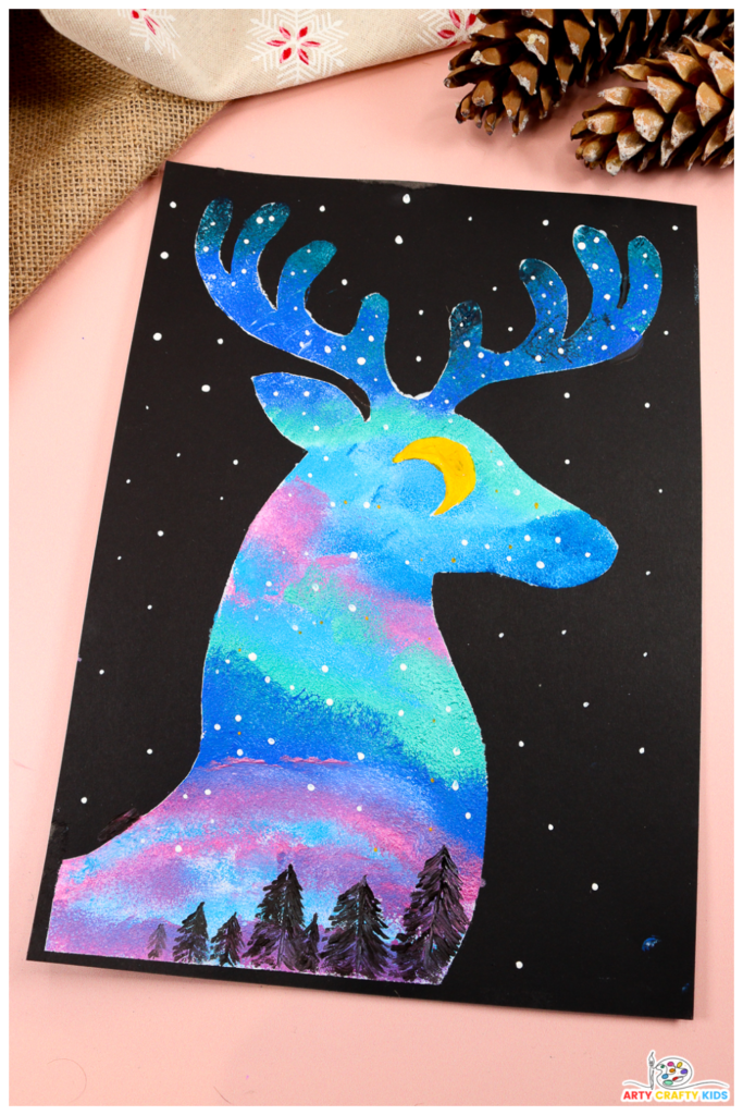 A colorful reindeer silhouette painting showcasing a vibrant northern lights-inspired night sky, emphasizing creative use of positive and negative space for a festive winter art project.