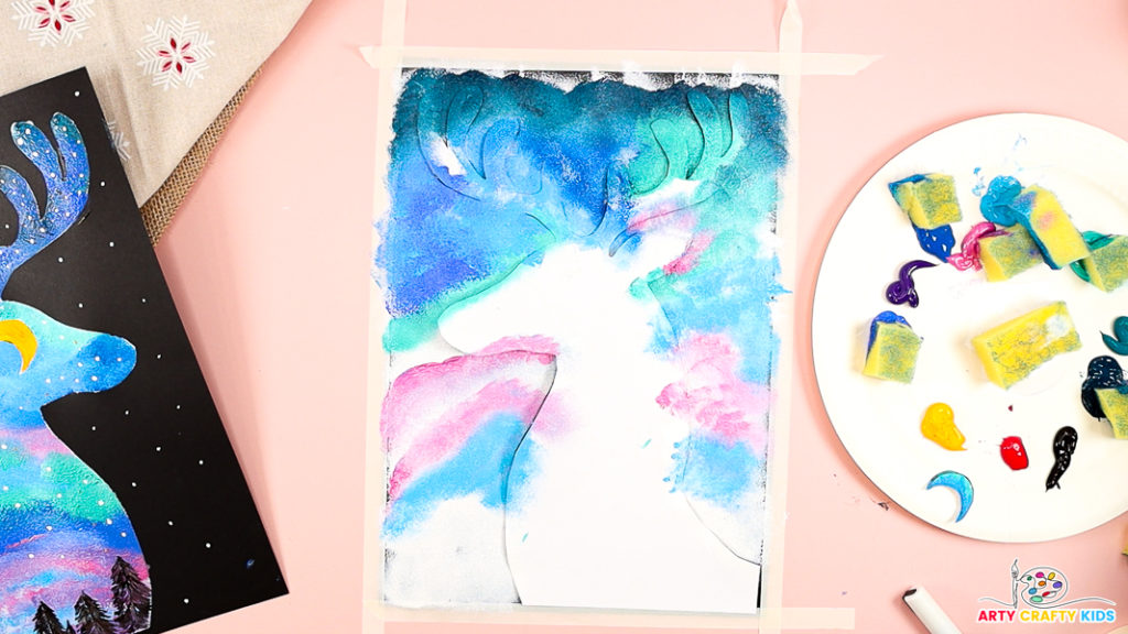 Image features colorful layers and waves of pink, blue and green paint around the reindeer silhouette.