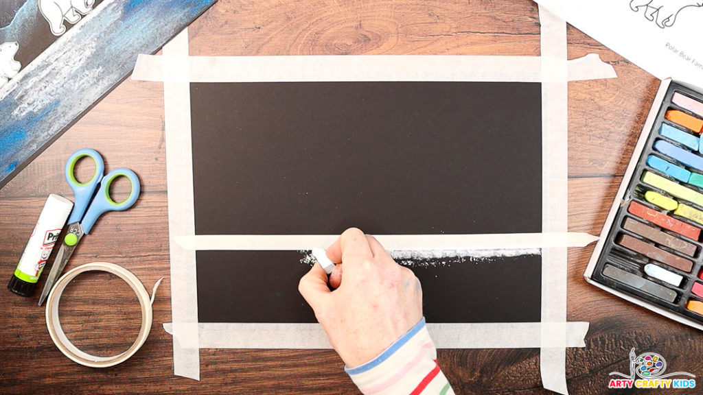 Image featuring a hand drawing a white bold line along a strip of masking tape.