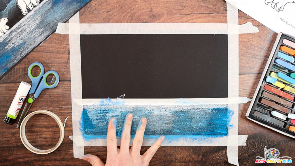 Image featuring a hand blending in the blue chalk pastel to create reflective waters.