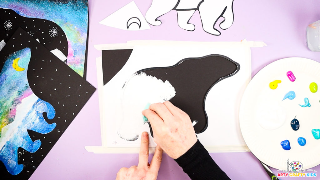 Image of a hand painting the polar bear white.