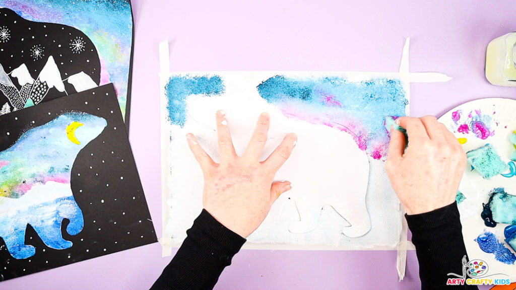 Image of hand layering the white paint with blue, pink and green colours.