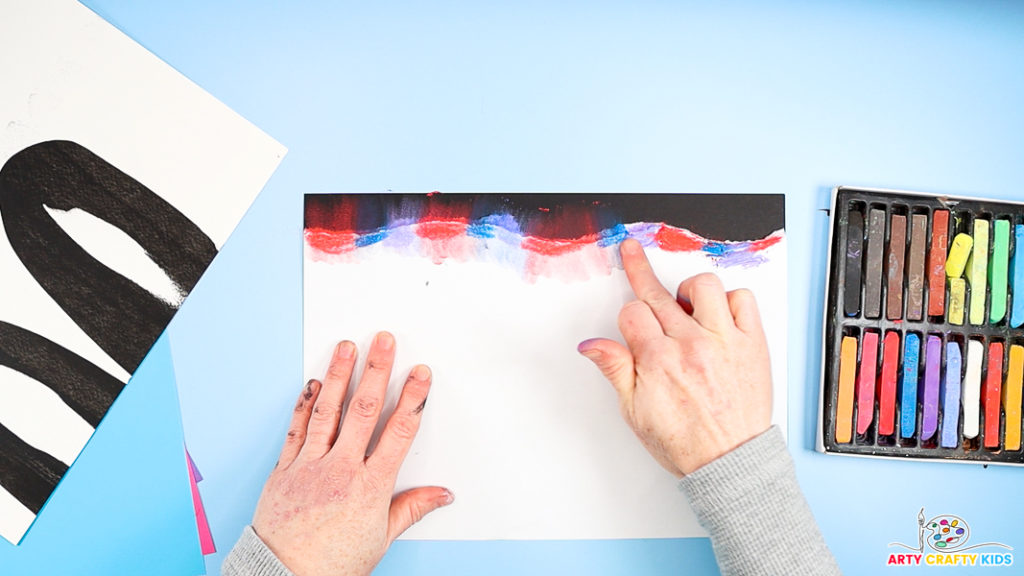 Image of hand rubbing the chalk onto the black card stock.