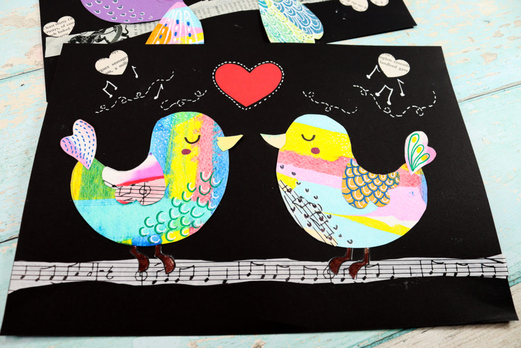 Final Love Bird Collage Display: A completed collage featuring two colorful love birds surrounded by hearts and patterns on black cardstock.